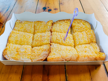Grilled butter toast, golden brown crispy bread topped with sugar and sweetened condensed milk.の写真素材