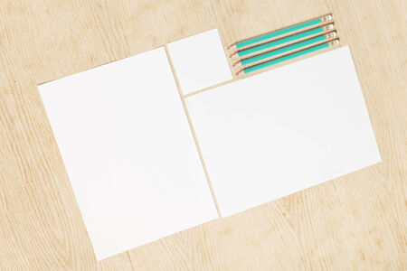 Blanks of empty paper with pencils on a wooden surface.の写真素材
