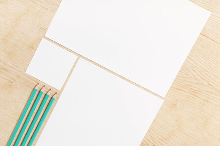 Blanks of empty paper with pencils on a wooden surface.の写真素材