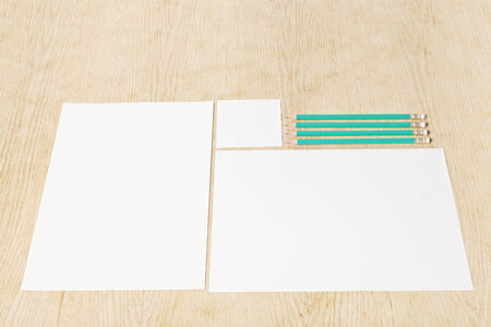 Blanks of empty paper with pencils on a wooden surface.の写真素材