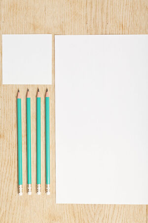 Blanks of empty paper with pencils on a wooden surface.の写真素材