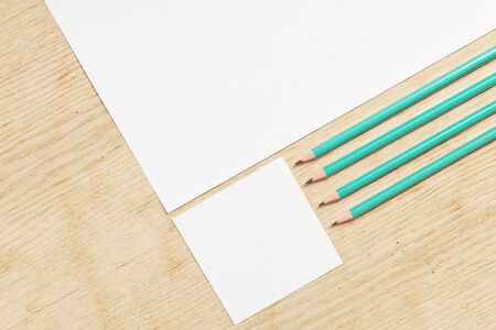 Blanks of empty paper with pencils on a wooden surface.の写真素材