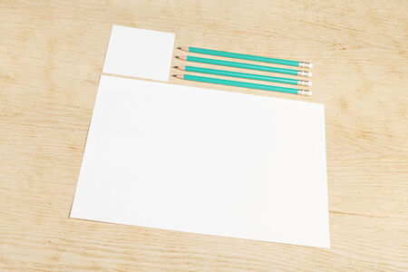 Blanks of empty paper with pencils on a wooden surface.の写真素材