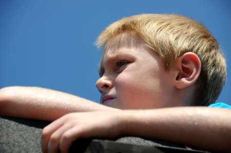 A cute young boy enjoys the park while posing for photographs on a summer day.の写真素材