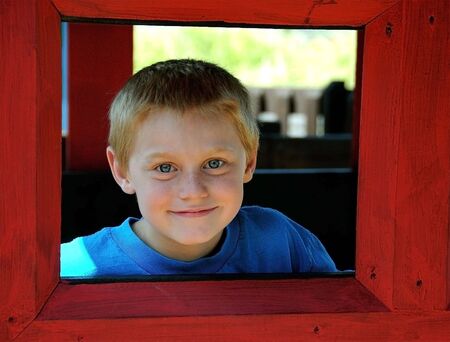 A cute young boy enjoys the park while posing for photographs on a summer day.の写真素材