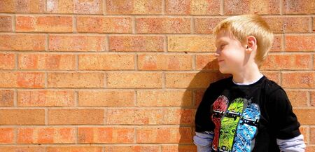 A cute young boy enjoys posing for photographs on a summer day.の写真素材