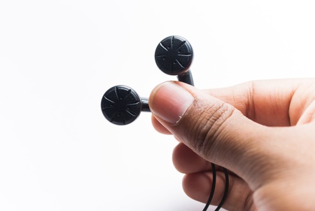 holding earphones with hand on white backgroundの写真素材