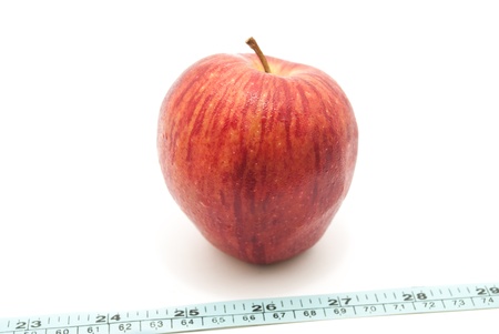 fresh red farm apple and measuring tailor tape on white isolated backgroundの写真素材
