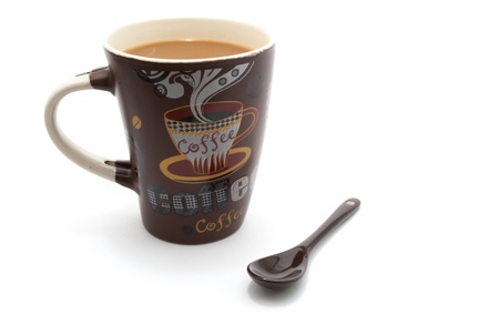 a coffee mug full of coffee with milk and sppon for mixing on white isolated backgroundの写真素材
