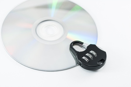 compact disk with a security lock on it conceptual isolated imageの写真素材