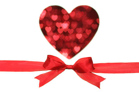 Red ribbon and heart shaped blurry pattern on white background.の写真素材