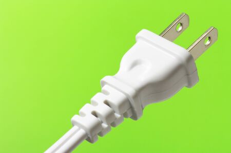white electric plug on green background (horizontal) のeditorial素材