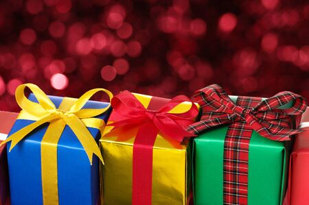 Three gifts on red blurry lights background  の写真素材
