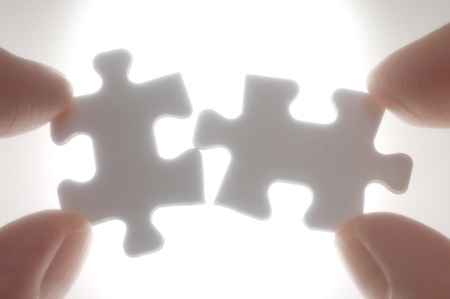 A person connecting puzzle pieces against the light Soft focus photograph  Concept image of building...