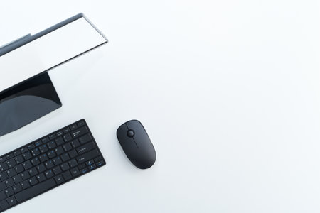 Top view of black desktop computer with blank display. Monitor, keyboard and mouse on white table.