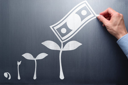 Success of investment and business. Business education. Businessman drawing growth of tree and money on chalkboard.の写真素材