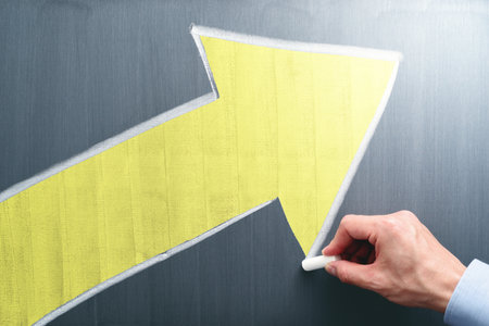 Businessman drawing yellow arrow on chalkboard. Business growth and development concept.