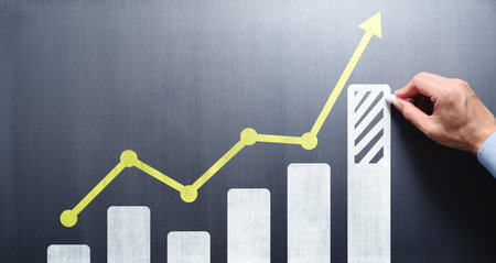 Business growth analysis and advice concept. Consultant drawing bar chart and line graph on chalkboard.の写真素材