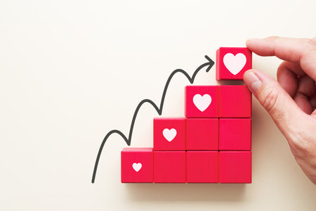 Growing heart. Mental growth. Hand putting wood blocks in staircase pattern.の写真素材