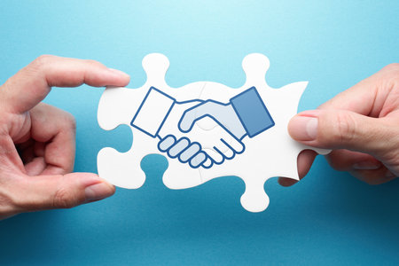 Strategy of business deal. Two hands connecting jigsaw puzzle pieces. Illustration of handshake.の写真素材