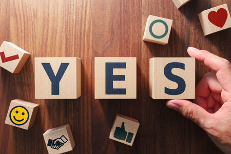 The word "YES". Positive answer concept. Putting wood cubes with alphabets and icons. Top view of wood table.の写真素材