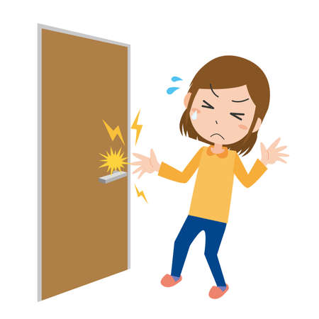 Woman hurt by static electricity trying to hold doorknobのイラスト素材