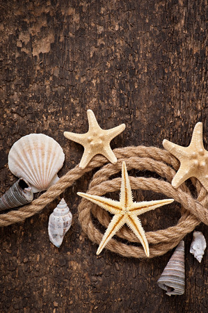 starfish, seashells and rope on old wooden backgroundの写真素材