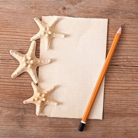 sheet of old paper, starfish on old wooden backgroundの写真素材