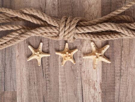 rope, starfish on the old wooden backgroundの写真素材