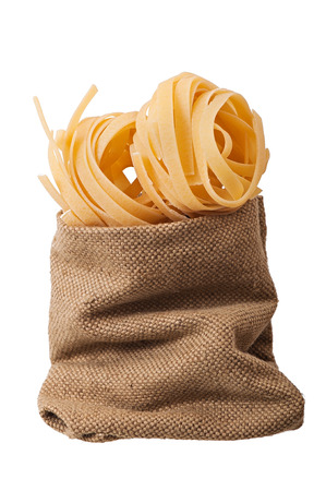 Pasta in a bag of old cloth isolated on white background.の写真素材