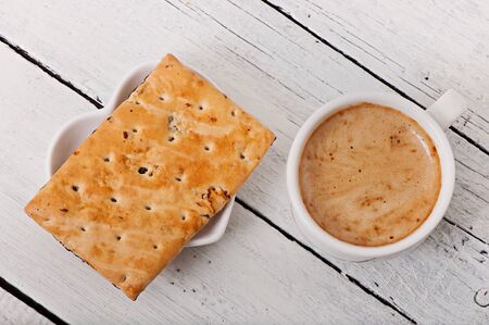 Cup of coffee and delicious baked cookies on old wooden background.の写真素材