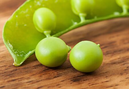 Sweet green peas on an old wooden background.の写真素材