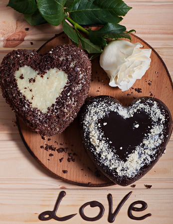 Chocolate baked in the shape of heart and beautiful light rose flower. Valentine's Day.の写真素材