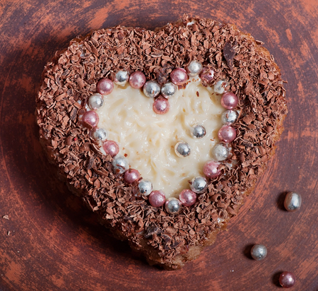 Chocolate pastry in the shape of heart on a brown plate. Valentine's Day.の写真素材