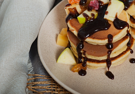Sweet pancakes with fruits, candied fruits and cheese, homemade, on a light background.の写真素材
