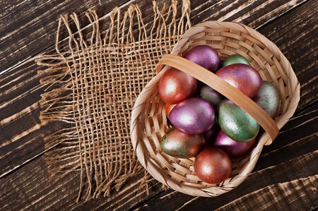 Easter eggs in a basket on an old wooden background.の写真素材