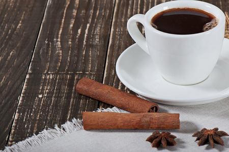 Food - a cup of hot aromatic coffee and spices on an old wooden background.の写真素材