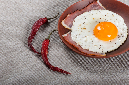 Fried egg on a clay plate, breakfast food.の写真素材