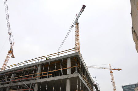 construction of building with cranes and scaffoldings