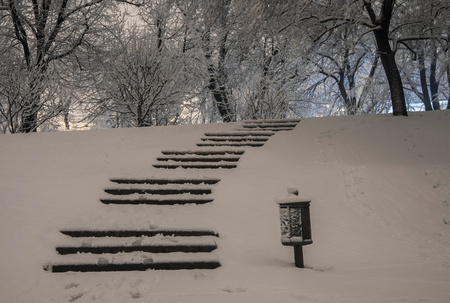 Stairway in winter snowy night with footprintsの写真素材