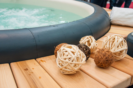 Detail view of luxury beautiful hot tub for relaxing, with decoration, towels, bottle of wine in nice interior.の写真素材
