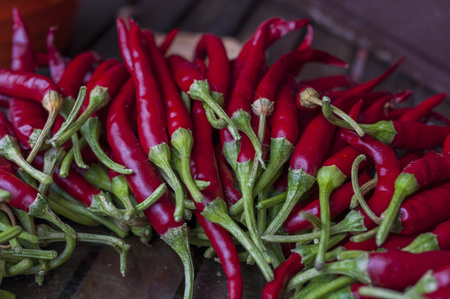 A lot of chilli peppers on wooden background. Hot red chilli pepper. Typical mexican food.