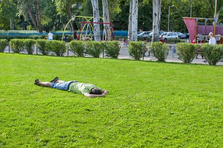 Man lying on grass and sleeping. Relaxing man lying on grass in summerのeditorial素材