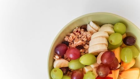 Bowl mÃ¼sli with fresh fruit on isolated background. MÃ¼sli grapes banana and nectarine in bowl on isolated background.の写真素材