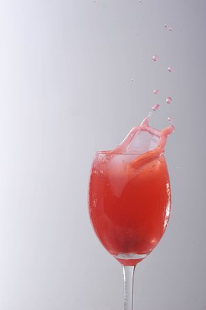 red liquid splashing in glassの写真素材