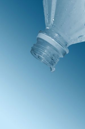 Water flows from  bottle on  blue backgroundの写真素材