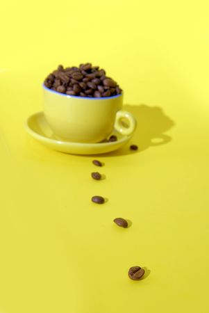 cooffee beans and cup on yellow backgroundの写真素材