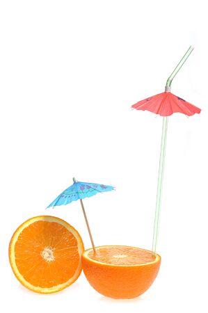 sliced orange with coctail umbrella on whiteの写真素材