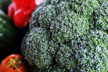 broccoli, tomatoes, carrots and  cucumber lie on table