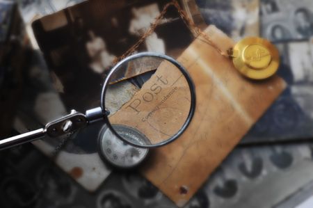 hand with reading-glass on the retro Post cardの写真素材